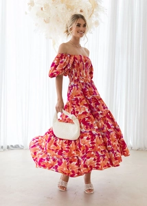 Detail of red floral off-shoulder dress with tiered skirt and puff sleeves on a model