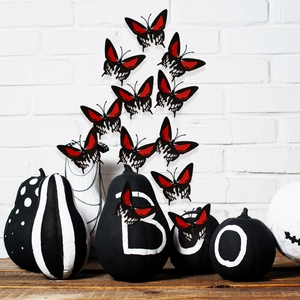 Halloween decor featuring skull pumpkins with BOO text and 3D butterfly wall stickers