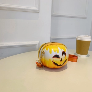 Detailed view of Halloween pumpkin crossbody bag with gold chain and smiley face