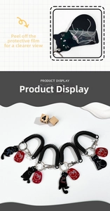 Close-up of cat acrylic keychain with black spring coil rope and decorative red tag