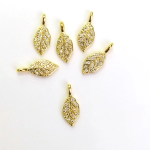 Pendentifs feuilles dorées avec sertissage en zircons blancs sur fond blanc