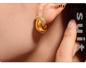 Close-up of model wearing crescent moon gold earrings with inlaid rhinestones in stainless steel