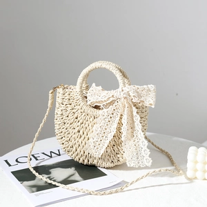 Beige straw woven bag with lace bow detail and shoulder strap for vacation style