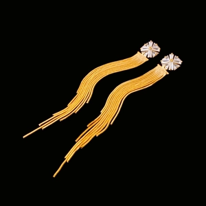 Macro shot of elegant gold tassel earrings with zircon stars on black background