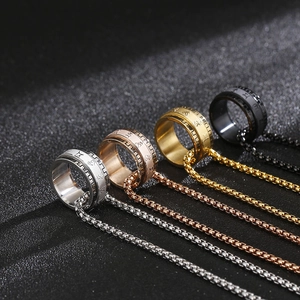 Detail view of four rotating stainless steel mantra rings in gold, silver, black, and rose gold