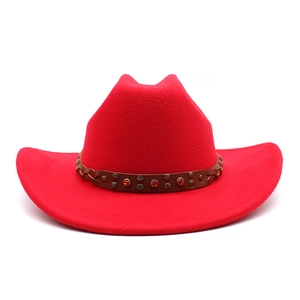 Détail d'un chapeau de cowboy en feutre rouge avec bande en cuir brun et strass orange