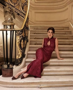 Détail de la robe maxi en dentelle bordeaux élégante avec col haut et découpe frontale