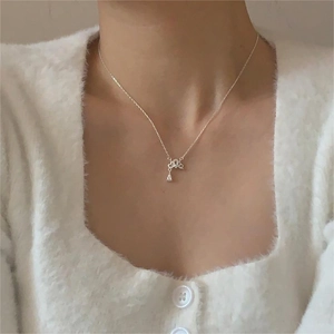Detail of 925 sterling silver necklace with bow pendant and drop-shaped zircon on a model