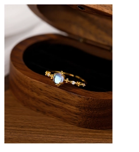 Detailed close-up of S925 silver moonstone ring with gold finish in a luxury box
