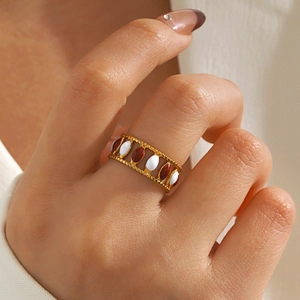 Chic gold stainless steel oval ring with white and brown enamel inlay on model's hand