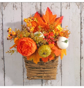 Close-up of autumn wall basket with orange maple leaves and mini pumpkins decor