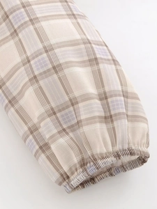 Detail of checkered blouse sleeve with elastic ruffled cuffs and colorful grid pattern