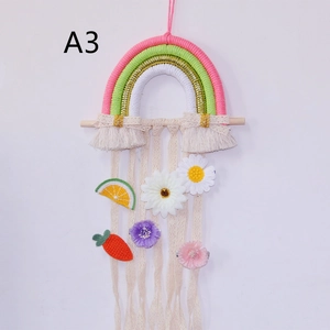Detail of woven rainbow wall hanging with lace tassels and crochet flowers for kids room