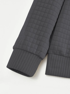 Detail of dark grey waffle knit texture and ribbed cuffs on casual long sleeve sweatshirt