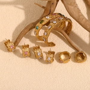 Detailed macro of vintage hammered 18K gold-plated jewelry set with colorful gemstones