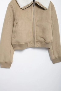 Détail de la veste en daim kaki avec col en fourrure et finition à bord-côte