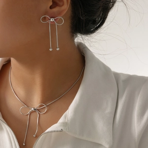 Elegant silver butterfly jewelry set featuring a necklace and earrings on a model
