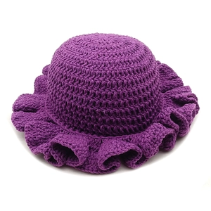 Close-up of dark purple hand-crocheted knit hat with ruffled brim texture detail