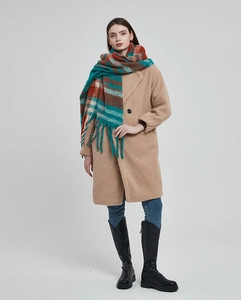 Detailed view of long plaid tassel scarf paired with camel teddy coat and denim jeans