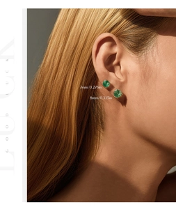 Close-up of 7mm and 8mm round cut green gemstone earrings with four-prong silver setting
