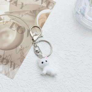 Detailed close-up of a white flocked cat doll keychain with a silver metal lobster clasp