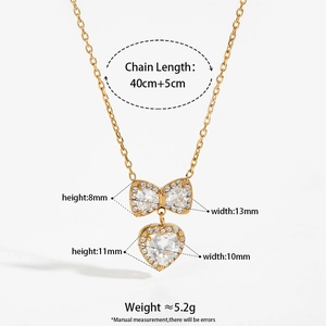 Gold stainless steel necklace with zircon bow and heart pendants on white background