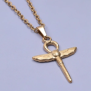 Macro shot of gold Ankh cross pendant with scarab and wings in stainless steel