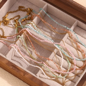 Layered 18K gold plated necklaces with colorful beads in a wooden jewelry box