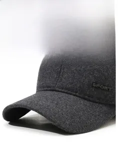 Detail view of a stiff charcoal wool baseball cap brim featuring a metal SPORT emblem