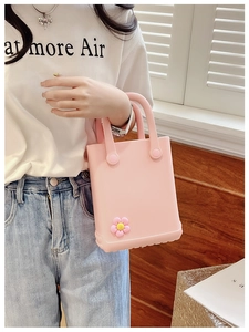 Detailansicht der rosa EVA-Strandtasche mit 3D-Blumenschmuck, gehalten von einem Model