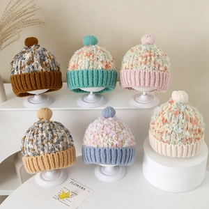 Detail van veelkleurige gebreide wintermutsen met pompons op trapsgewijze displaystandaards