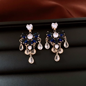 Detail of gold floral tassel earrings with navy marquise gems and sparkling white crystals