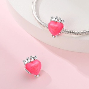 Macro detail of pink heart bead with silver bears and stones on a snake chain
