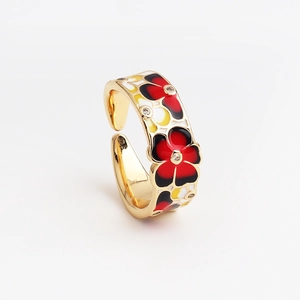 Detalle de anillo dorado ajustable con patrones florales de esmalte y pequeños diamantes