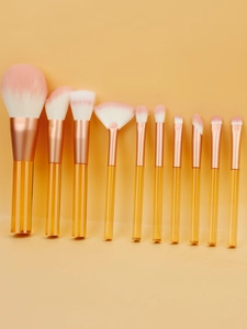 Close-up of 10-piece makeup brush set with clear yellow handles and soft pink bristles