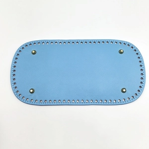 Detail of sky blue oval PU leather bag bottom with pre-punched holes and metal studs