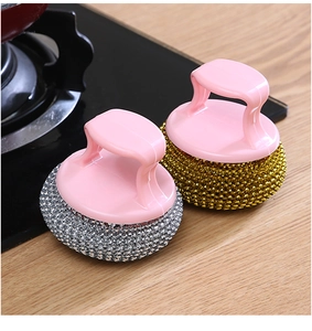 Detail of gold and silver steel mesh kitchen scrubbers with pink ergonomic handles