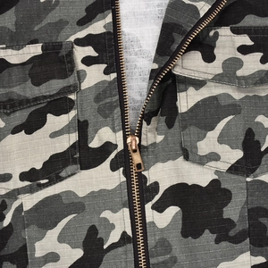 Close-up of camouflage jacket with metal zipper, chest pockets and ripstop fabric texture