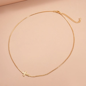 Detailed macro view of 18k gold plated cross pendant with lobster clasp and box chain link