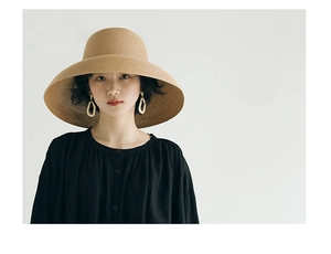 Close-up of khaki woven straw sun hat with detailed elegant texture for beach wear