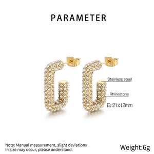 Détail macro de boucles d'oreilles en acier inoxydable doré serties de strass