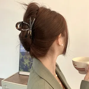 Elegant tortoiseshell bow hair claw clip for women shown in a stylish hairstyle
