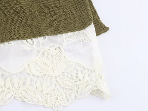 Close-up of olive green knit fabric joined with white floral lace embroidery detailing