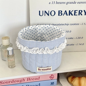 Blue striped fabric storage basket with white lace trim and dotted lining detail
