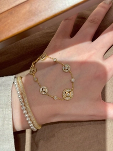 Detail of layered 18K gold plated star bracelet with pearls and zircon bangles