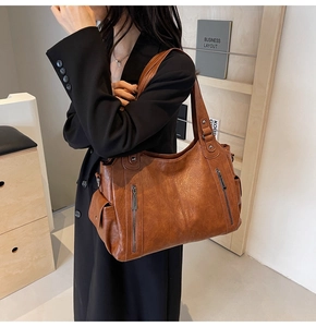Detailed view of a vintage brown leather tote bag showing large capacity and zipper texture