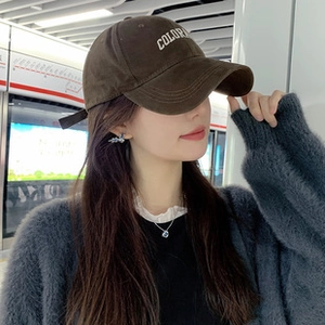 Brown suede baseball cap with white Colorado embroidery shown on a model in a subway