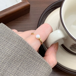Minimalist gold pearl ring shown on hand holding a coffee cup for a lifestyle aesthetic