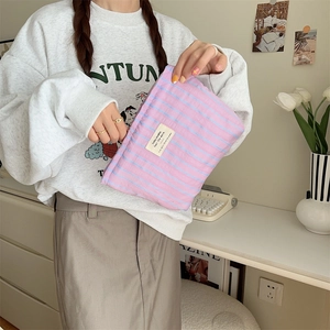 Handheld striped canvas makeup bag with pink and blue lines and top zipper closure