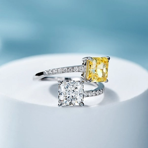 Macro shot of silver princess cut rings with yellow and white square stones on a stand